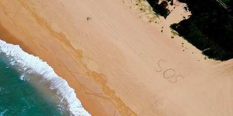 Ένα αυτοσχέδιο μήνυμα «SOS» γραμμένο στην άμμο αποδείχθηκε καθοριστικό για τη διάσωση δύο επισκεπτών στη Χαβάη, της Emma Stasko και του Logan Bonn / FACEBOOK