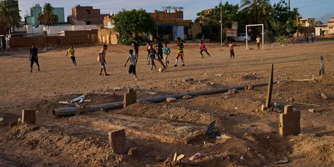 Παιδιά παίζουν ποδόσφαιρο σε δημόσιο πάρκο δίπλα σε νεκροταφείο