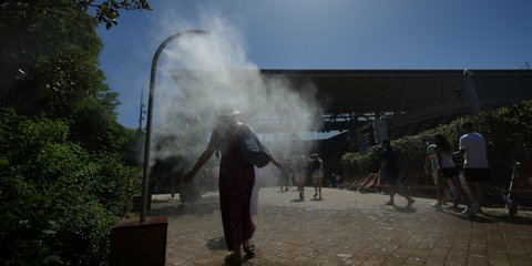 Καύσωνας στη Γαλλία: Θεατές του Ρολάν Γκαρός δροσίζονται σε ψεκαστήρες νερού / Φωτογραφία: AP Photo/Aurelien Morissard