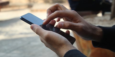 Άνδρας χρησιμοποιεί ένα τηλέφωνο με λογισμικό Android
