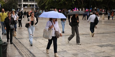 People with umbrellas in Athens