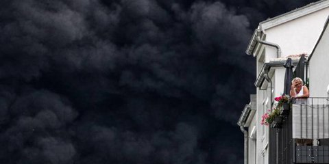 Μια γυναίκα στέκεται στο μπαλκόνι του σπιτιού της «ατενίζοντας» το μαύρο τοξικό νέφος που έχει σκεπάσει τον ουρανό της Ρηνανίας στη Γερμανία. Προήλθε από έκρηξη σε εργοστάσιο 4.800 τόνων πέλετ