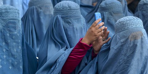 Φωτιά κάτω από τη μπούργκα. Μια Αφγανή, ανάμεσα σε γυναίκες-φαντάσματα τυλιγμένες με μπούργκα, σηκώνει το κινητό και παίρνει φωτογραφία σε εκδήλωση του Abdullah Abdullah, υποψήφιου για την προεδρία της χώρας και κύριου αντιπάλου του Χαμίντ Καρζάι.