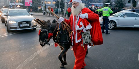 Ενας ταπεινός Αϊ-Βασίλης με το γαϊδουράκι του, στη Ρουμανία -Φωτογραφία: AP Photo/Vadim Ghirda