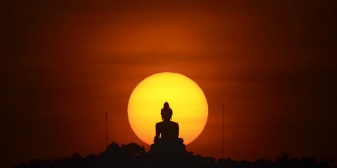 Ηλιοβασίλεμα πίσω από το άγαλμα του Βούδα στα Πουκέ, στην Ταϊλάνδη / REUTERS