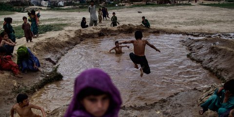 Παιδιά από το Αφγανιστάν κολυμπούν σε λίμνη από λασπόνερα σε προσφυγικό καταυλισμό στο Ισλαμαμπάντ. Στο Πακιστάν, σύμφωνα με τα Ηνωμένα Εθνη, ζει ο μεγαλύτερος προσφυγικός πληθυσμό στον κόσμο, αποτελούμενος από 1,6 εκατομμύρια Αφγανούς 