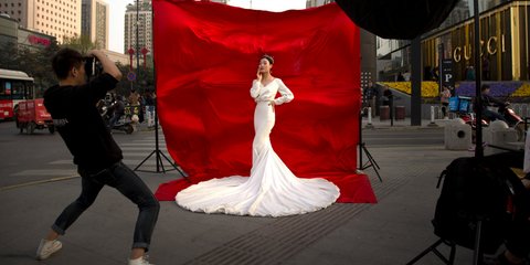 Μια γυναίκα με νυφικό ποζάρει σε δρόμο της Xi'an στη νοτιοδυτική Κίνα, όπου βρίσκεται ο πήλινος στρατός -Φωτογραφία: AP Photo/Mark Schiefelbein