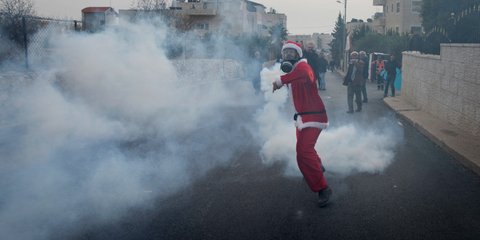 Χριστούγεννα στην Βηθλεέμ: Παλαιστίνιος επιστρέφει δακρυγόνο σε Ισραηλινούς αστυνομικούς -Φωτογραφία: AP Photo/Nasser Nasser
