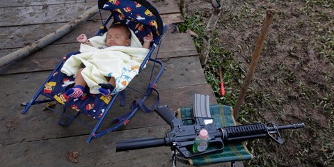 Μια άλλη εκδοχή της ημέρας της γυναίκας: Αντάρτισσα του FARC στην Κολομβία κοιμίζει το γιο της δίπλα στο όπλο της -Φωτογραφία: AP Photo/Fernando Vergara