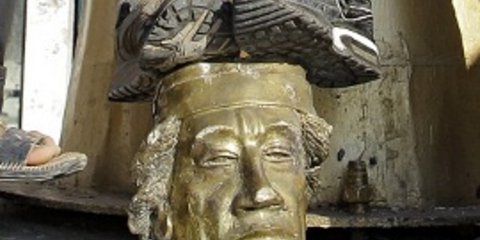 Αντάρτες πατάνε πάνω σε προτομή του Καντάφι, ουρλιάζοντας ότι θα τον πιάσουν όπου κι αν κρυφτεί, αμέσως μετά την πτώση του Αρχηγείου του