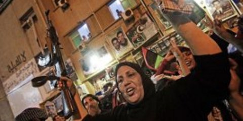 Μια λίβυα γυναίκα πανηγυρίζει κρατώντας όπλο μαζί με χιλιάδες συμπολίτες της χτες το βράδυ στη Βεγγάζη