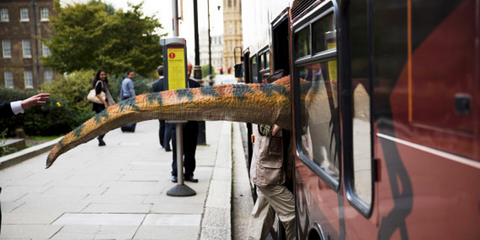 Δεινόσαυροι επιβιβάζονται στα λεωφορεία του Λονδίνου; Οχι ακριβώς. Ο στόχος του καλλιτέχνη ο οποίος φοράει μια ψεύτικη ουρά δεινοσαύρου και μπαίνει μέσα στο λεωφορείο είναι να προωθήσει μια εικαστική έκθεση που αναμένεται να εγκαινιαστεί την επόμενη εβδομ