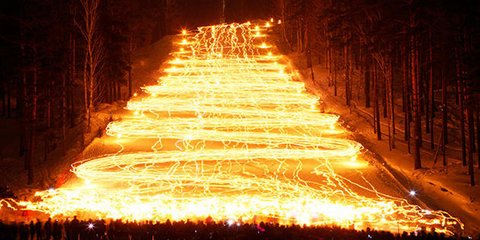 Eντυπωσιακή κατάβαση πλαγιάς από σκιέρ που κρατούν δάδες 