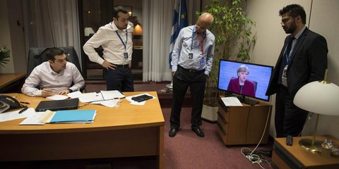 Ο Αλέξης Τσίπρας παρακολουθεί από το γραφείο του στις Βρυξέλλες τις δηλώσεις της Ανγκελα Μέρκελ / Φωτογραφία: Sooc