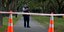 Αστυνομικός κρατά το όπλο του πίσω από πορτοκαλί κώνους