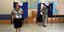 Δυο ψηφοφόροι βγαίνουν από τα παραβάν εκλογικού τμήματος, κατά τις εκλογές του 2015