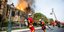Γάλλοι πυροσβέστες κουβαλούν μάνικες μπροστά στη φλεγόμενη Παναγία των Παρισίων