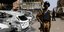 Ενοπλος άνδρας στη Μπουρκίνα Φάσο μπροστά σε καμμένα αυτοκίνητα
