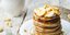 Pancakes σε λευκό πιάτο με κομμάτια μπανάνας και μέλι
