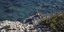 Ζευγάρι κάθεται σε βράχια σε θάλασσα της Αμοργού