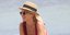 Η Χριστίνα Κοντοβά με κόκκινο μαγιό και καπέλο στην παραλία της Μυκόνου