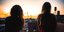 Δύο γυναίκες με μακριά ατενίζουν το ηλιοβασίλεμα