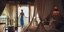 Μια γυναίκα με γαλάζιο φόρεμα σε ένα υπνοδωμάτιο με βεράντα 