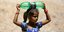 Κοριτσάκι από την Ινδία κρατά ένα μπουκάλι νερό