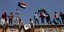 Κόσμος με σημαίες Σουδάν πάνω σε τοίχο