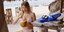 Γυναίκα με μπικίνι στην παραλία τρώει καρύδα