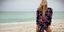 Η Kate Moss γονατισμένη στην άμμο φορώντας ένα φλοράλ φόρεμα