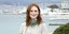 Η Τζούλιαν Μουρ με φόρεμα μεταλιζέ χαμογελάει με φόντο τη θάλασσα