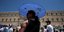 Μια γυναίκα προστατεύεται από τον καύσωνα με ομπρέλα