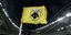 Κιτρινόμαυρο σημαιάκι της ΑΕΚ σε ποδοσφαιρικό γήπεδο