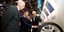 Ο Εμανουέλ Μακρόν με τον πρόεδρο και τον CEO της Michelin κοιτάζουν ένα λάστιχο της εταιρείας