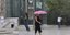 Γυναίκα κρατά ομπρέλα στη βροχή στο Σύνταγμα