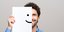 Άνδρας χαμογελά κρατώντας στο χέρι του ένα χαρτί με ένα χαμογελαστό emoticon 