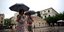 Ζευγάρι με ομπρέλες στη βροχή στην Αθήνα