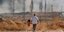 άνδρας κρατά από το χέρι κοριτσάκι στη βομβαρισμένη Συρία