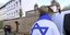 Άνδρας τυλιγμένος με σημαία του Ισραήλ λίγα μέτρα από το σημείο όπου έπεσαν νεκροί δύο άνθρωπο σε Συναγωγή στην Γερμανία