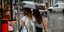 Γυναίκες με μαύρη ομπρέλα στον δρόμο