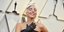 η Lady Gaga χαμογελά με μαύρο φόρεμα και γάντια σε βραβεία