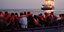 Μετανάστες με σωσίβια σε λέμβο απέναντι σε πλοίο