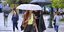 Γυναίκα κρατάει ομπρέλα στη βροχή