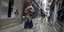 Γυναίκα κουβαλά την βαλίτσα στην πλάτη στα πλημμυρισμένα σοκάκια της Βενετίας