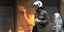 Αστυνομικός των ΜΑΤ και στο βάθος φλόγες από μολότοφ, στο μαθητικό-φοιτητικό συλλαλητήριο 