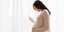 Έγκυος γυναίκα τραβά κουρτίνα 