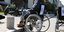 Γυναίκα σε αναπηρικό καροτσάκι ανεβαίνει σε πεζοδρόμιο