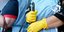 Καθαρίστρια κρατάει σκούπα με τα γάντια