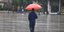 Ανδρας με ομπρέλα περπατά στη βροχή